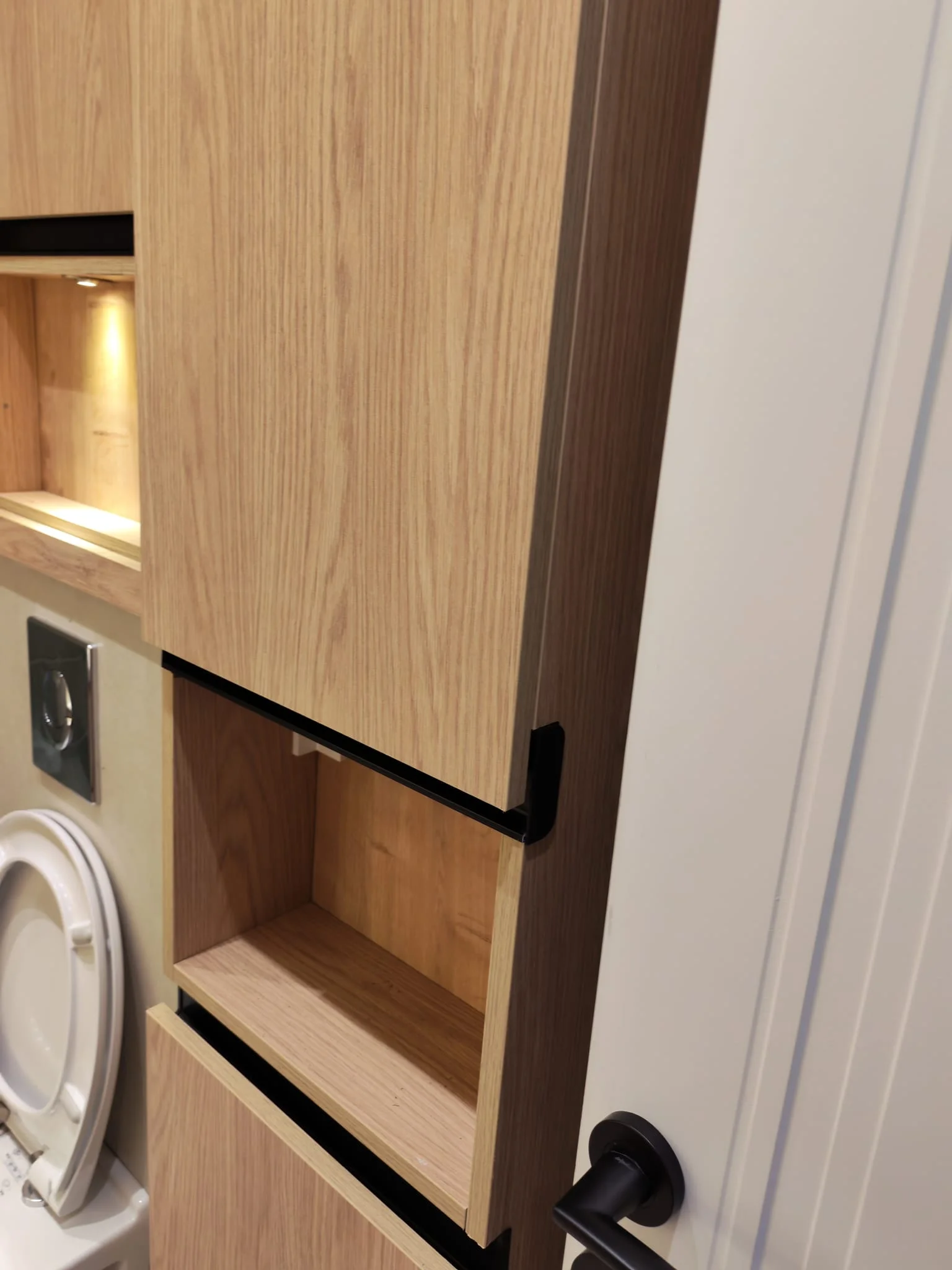 Ahşap banyo dolabı içinde çamaşır makinesi, açık raf ve çekmece düzeni